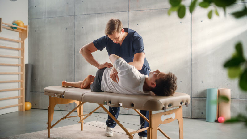 terapia manualna barku pacjent w trakcie terapii manualnej barku z fizjoterapeutą