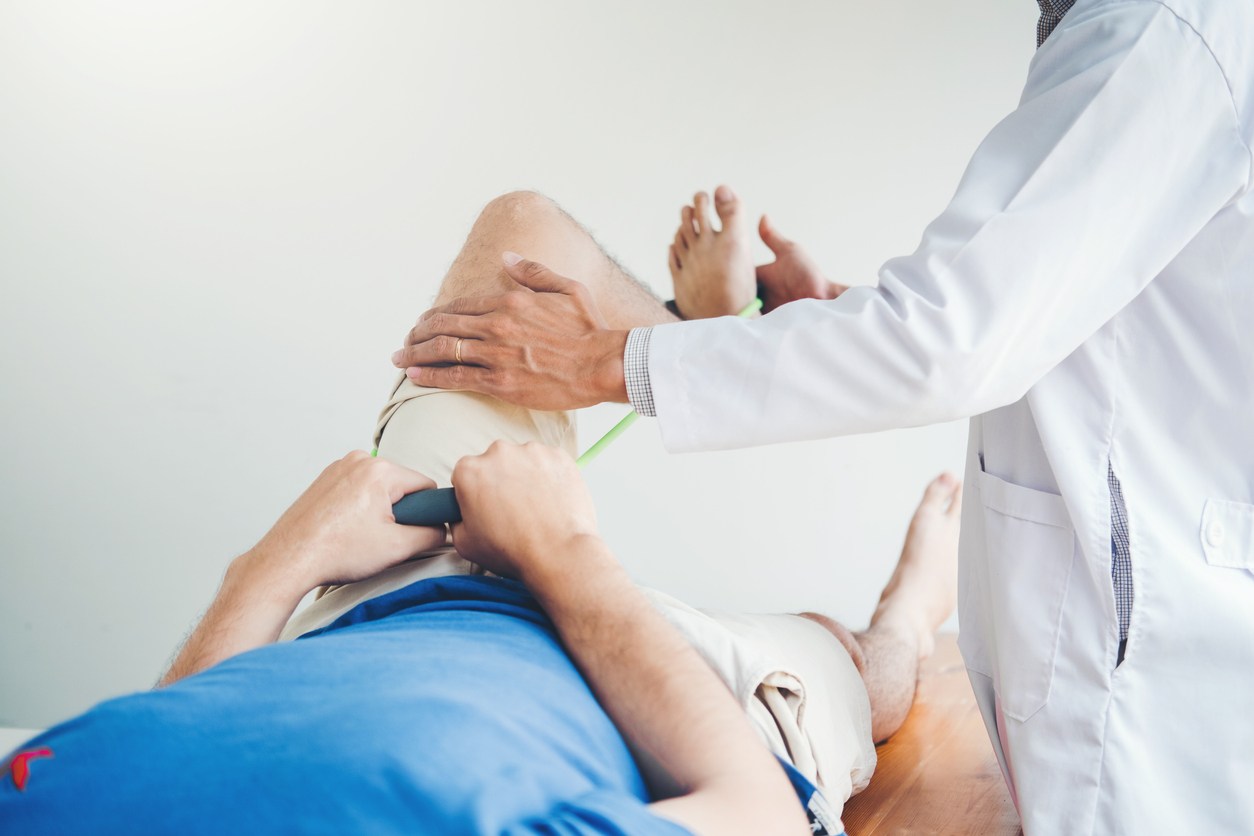Terapeuta prowadzi mobilizację stawu łokciowego po przebytym urazie