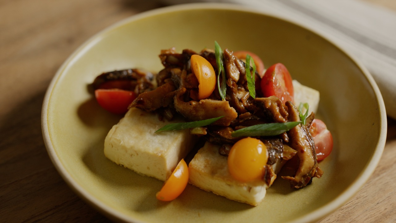 Gotowane jajka sadzone obok kostki tofu na białym tle kuchennym